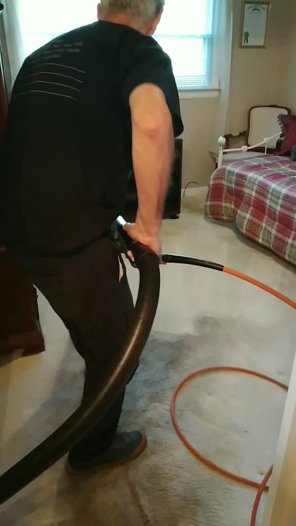 H & L Facility Services technician cleaning carpet in a client's home